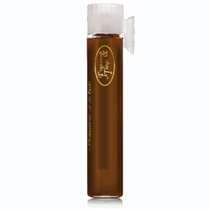 Tall glass with dark brown liquid and foam on top.
