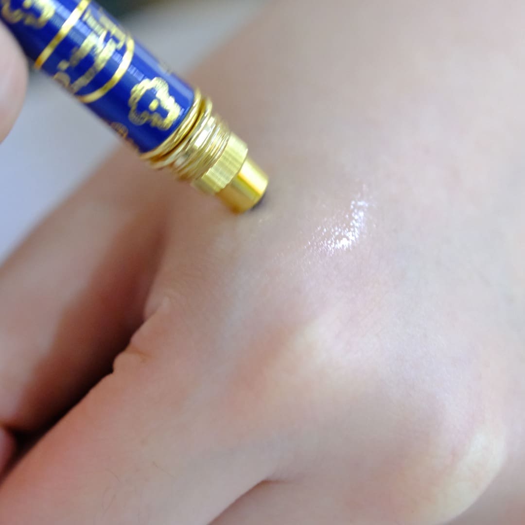 Applying balm to hand with tube.